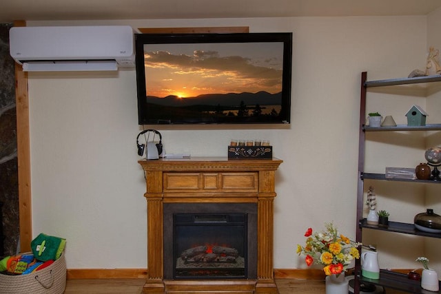 interior details featuring baseboards, a fireplace, wood finished floors, and a wall mounted AC