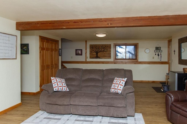 living room with baseboards, wood finished floors, and beamed ceiling