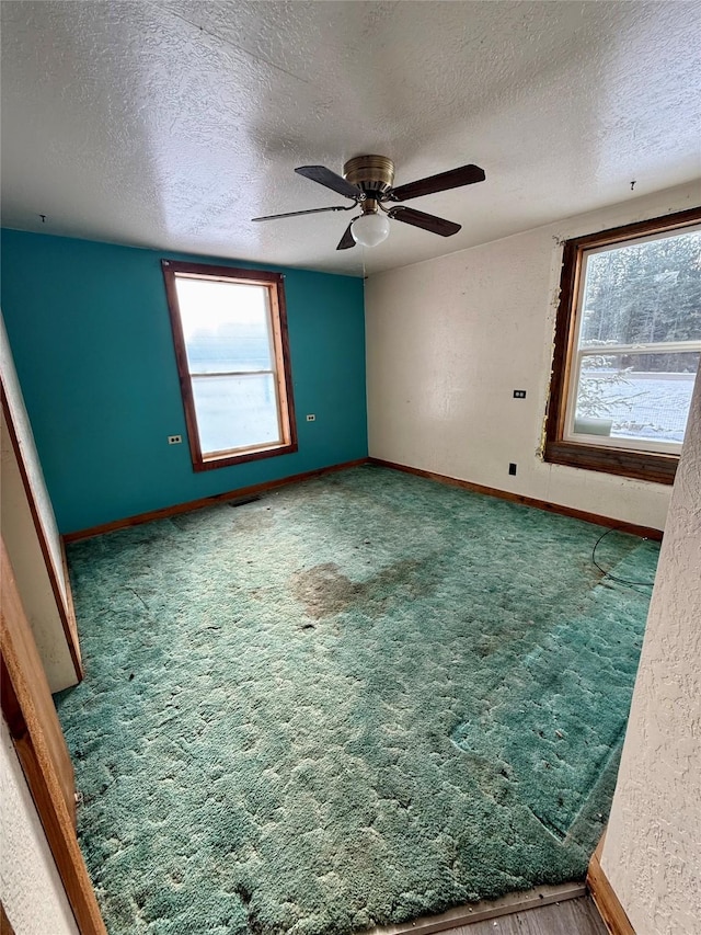 empty room featuring ceiling fan and a textured ceiling