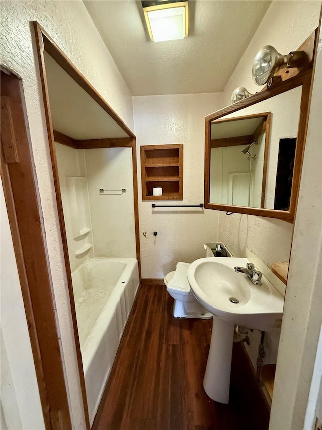 full bathroom with a textured ceiling, sink, toilet, hardwood / wood-style flooring, and bathtub / shower combination