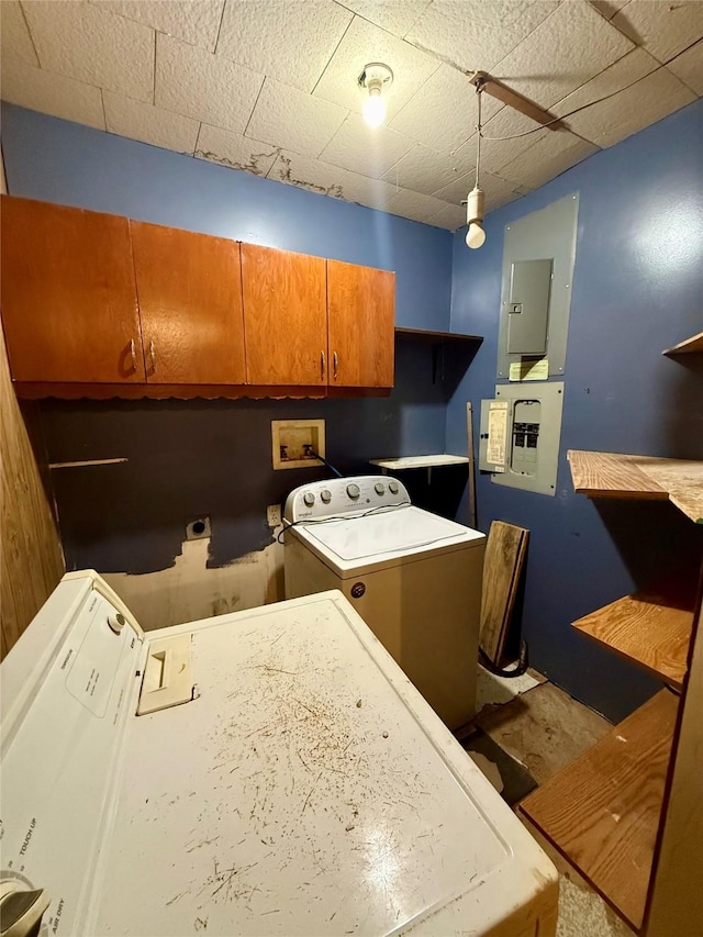 clothes washing area featuring electric panel, separate washer and dryer, and cabinets