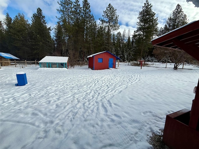 snowy yard featuring a storage shed