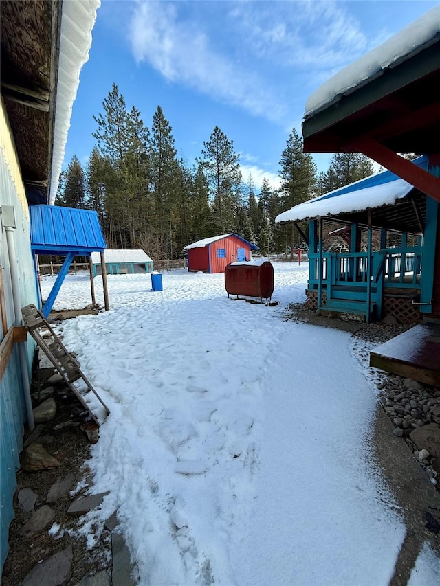 yard layered in snow featuring an outbuilding