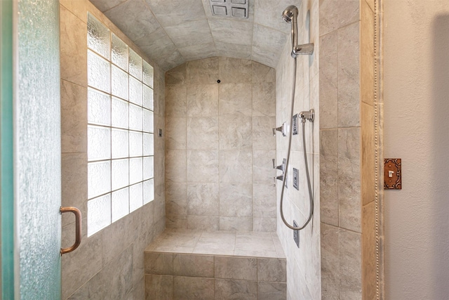 bathroom with vaulted ceiling and a shower with shower door