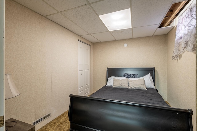 bedroom with carpet floors and a drop ceiling