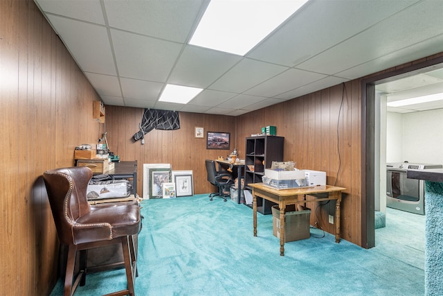 carpeted office featuring a paneled ceiling and wooden walls