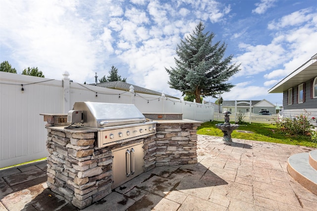 view of patio / terrace featuring a grill and an outdoor kitchen