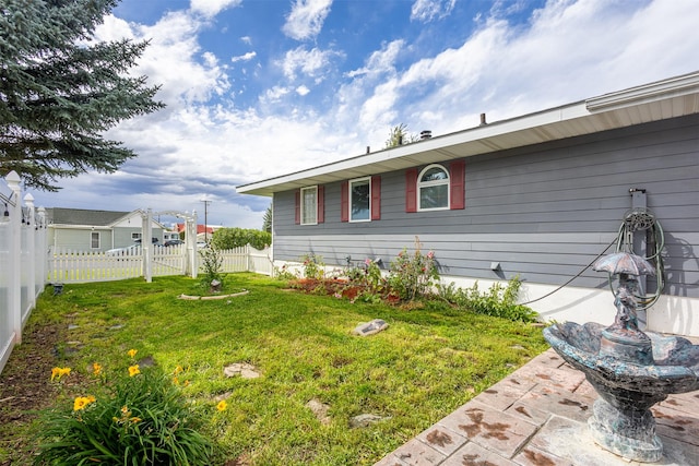 view of side of property featuring a patio and a yard