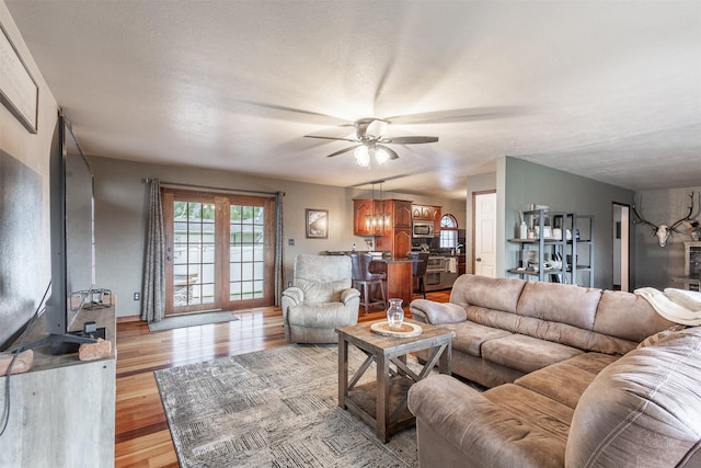 living room with ceiling fan and light wood-type flooring