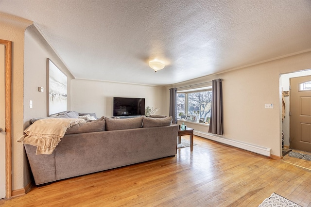 living room with light wood-type flooring, baseboard heating, and a textured ceiling