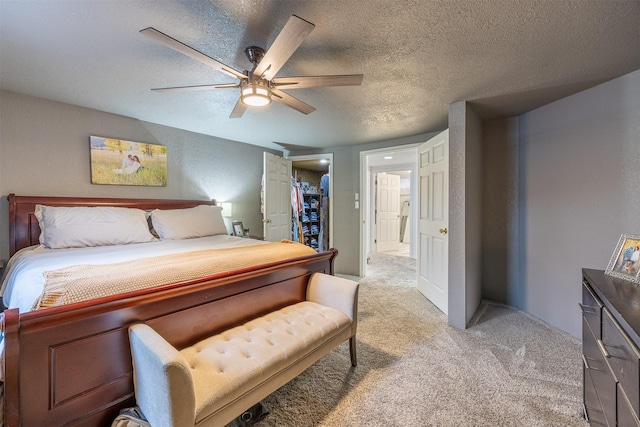 carpeted bedroom featuring a textured ceiling and ceiling fan