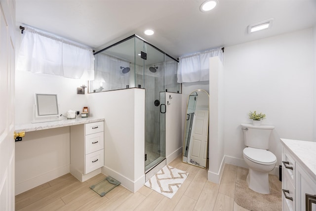 bathroom featuring an enclosed shower, vanity, and toilet