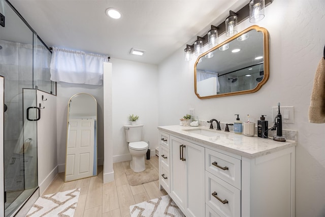 bathroom with an enclosed shower, vanity, and toilet