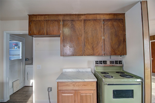 kitchen with washer / dryer, dark hardwood / wood-style flooring, and electric range