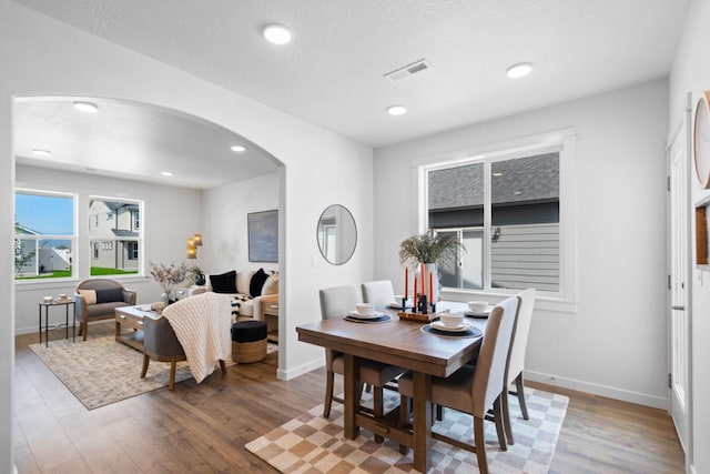 dining space with dark hardwood / wood-style floors and a textured ceiling