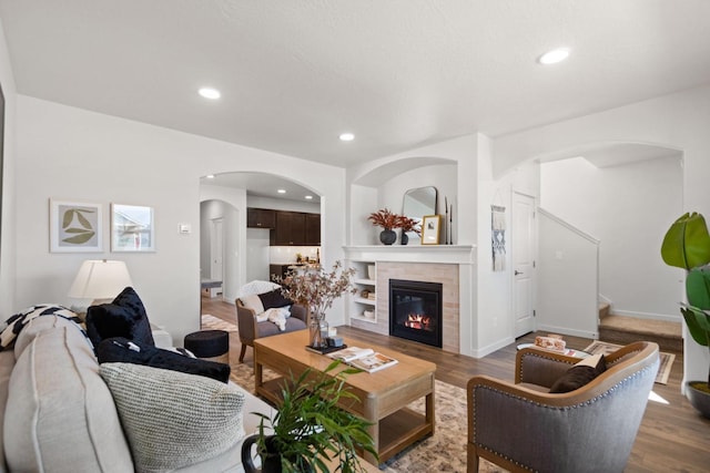 living room with a fireplace, hardwood / wood-style flooring, and built in shelves