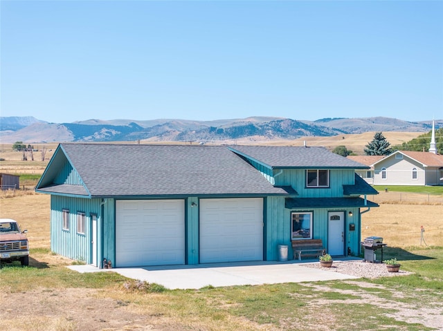 7 Hardy Cir, Ennis, MT 59729 - view of front facade featuring a mountain view, a shingled roof, an attached garage, and driveway