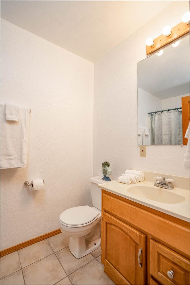 bathroom featuring toilet, vanity, tile patterned floors, and curtained shower