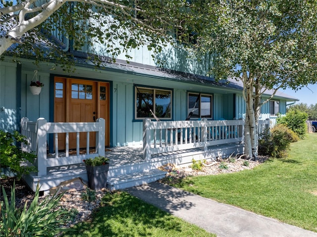 7 Hardy Cir, Ennis, MT 59729 - view of front of house featuring covered porch, board and batten siding, a front yard, and metal roof