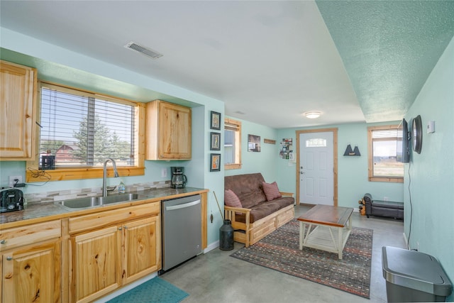 kitchen with a textured ceiling, dishwasher, light brown cabinets, and sink