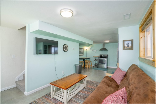 7 Hardy Cir, Ennis, MT 59729 - living area featuring finished concrete flooring, baseboards, stairs, and a wood stove