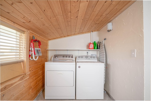 clothes washing area featuring wood ceiling, washer and dryer, and wood walls