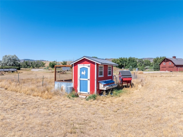 view of outbuilding with a rural view and a mountain view