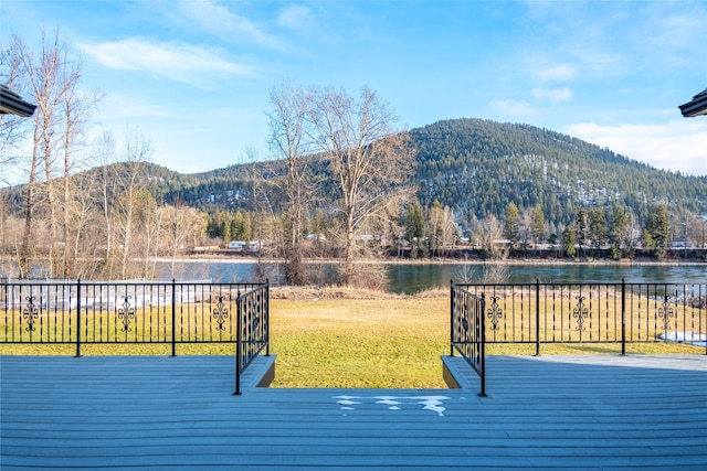 exterior space featuring a water and mountain view and a yard