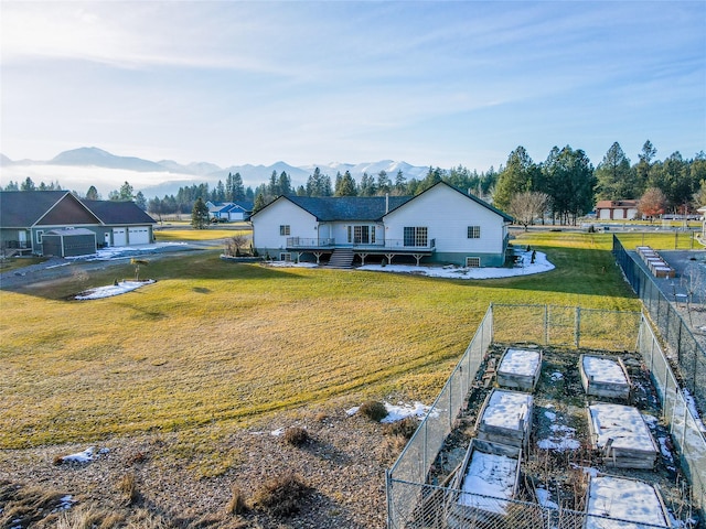 back of house with a lawn and a mountain view