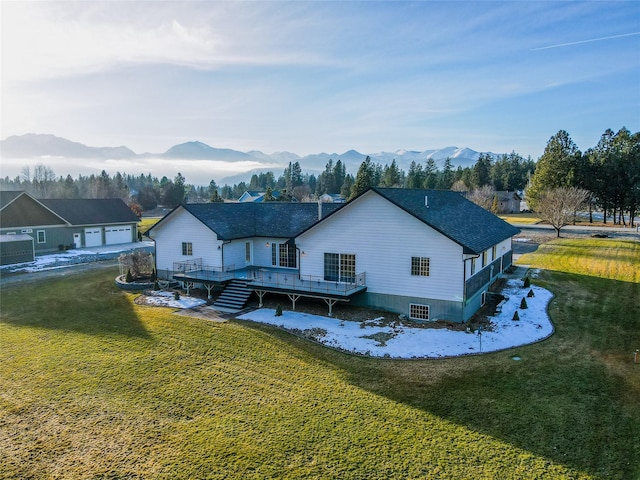 rear view of property with a lawn and a deck with mountain view