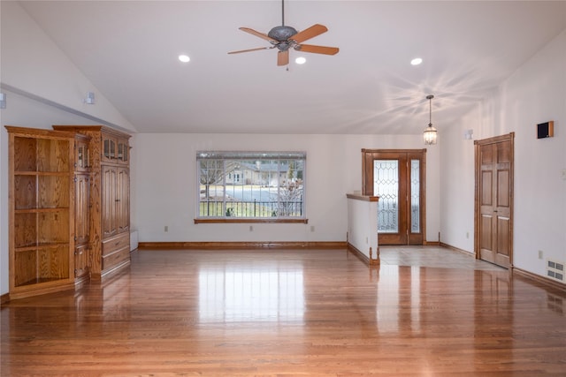 unfurnished living room with ceiling fan, light hardwood / wood-style floors, and vaulted ceiling