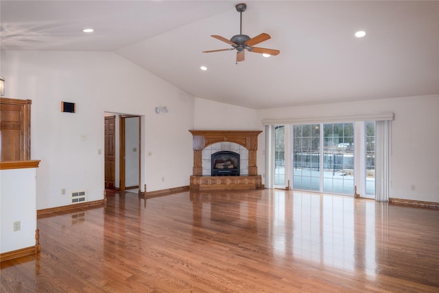 unfurnished living room with ceiling fan, hardwood / wood-style floors, a fireplace, and lofted ceiling