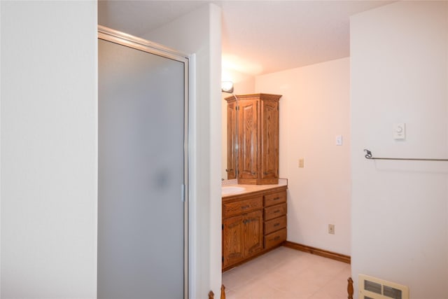 bathroom with a shower with shower door and vanity