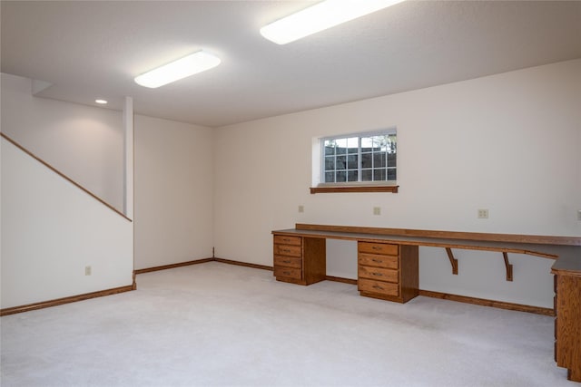 unfurnished office featuring light carpet and built in desk