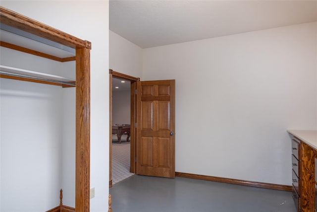 unfurnished bedroom with a closet and concrete flooring