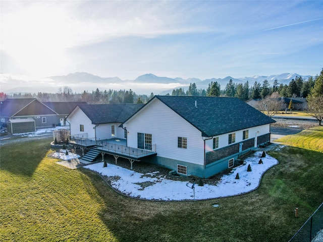 back of house featuring a lawn and a deck with mountain view