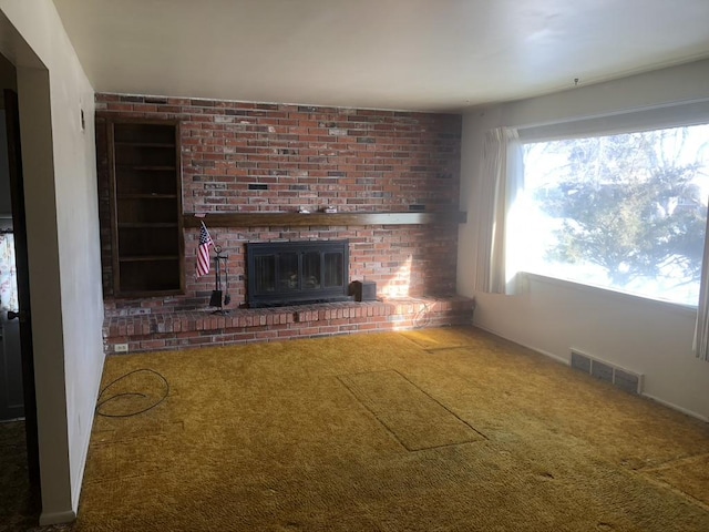 unfurnished living room with carpet floors and a fireplace