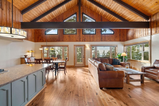 living room featuring beamed ceiling, light hardwood / wood-style flooring, and high vaulted ceiling