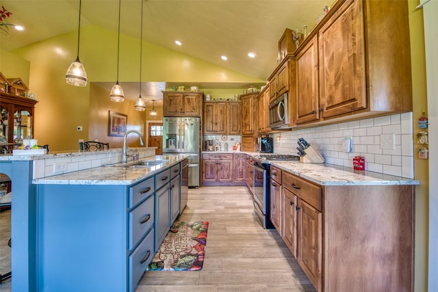 kitchen featuring light stone counters, hanging light fixtures, a center island with sink, and stainless steel appliances