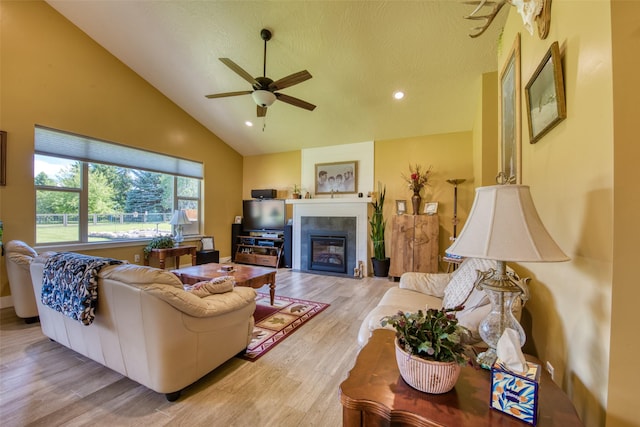 living room featuring ceiling fan, high vaulted ceiling, and light hardwood / wood-style floors