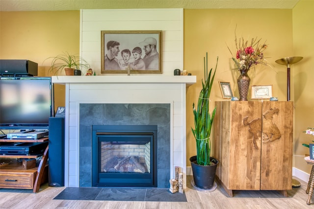 details featuring hardwood / wood-style flooring and a tiled fireplace