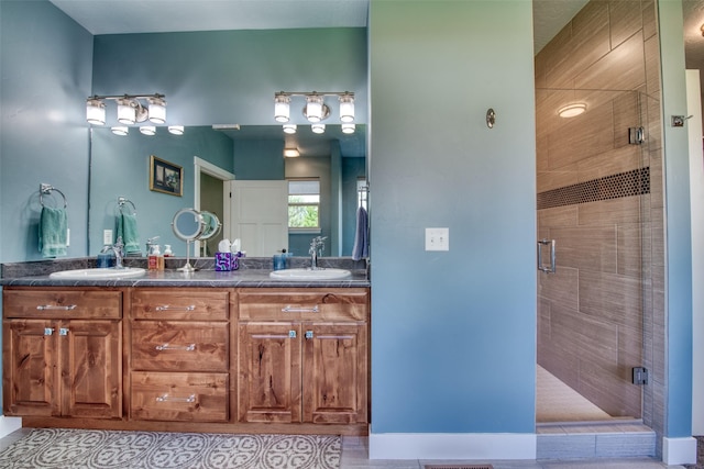 bathroom featuring tile patterned flooring, a shower with shower door, and vanity