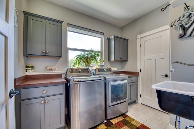 laundry room with cabinets, separate washer and dryer, and sink