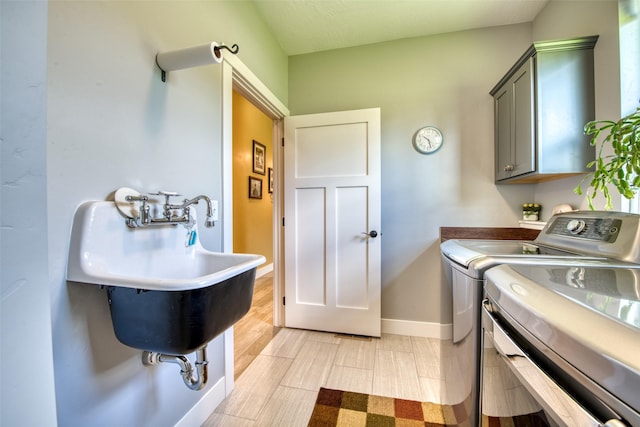 laundry area with light hardwood / wood-style floors, cabinets, and separate washer and dryer