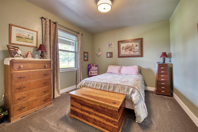 bedroom featuring dark carpet and a textured ceiling