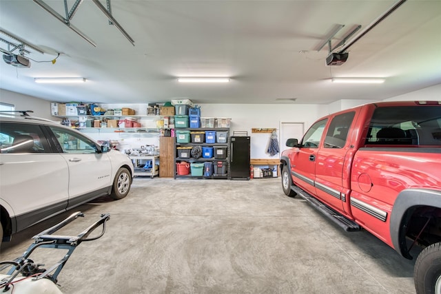 garage with a garage door opener and black refrigerator