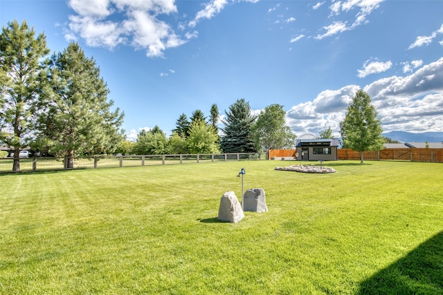 surrounding community with a yard, a rural view, and a shed