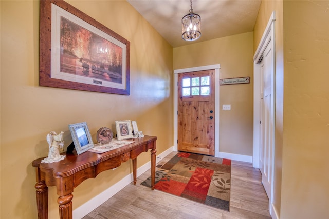 foyer entrance featuring light wood-type flooring and an inviting chandelier