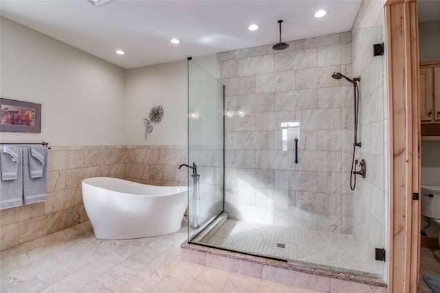 bathroom featuring plus walk in shower and tile walls