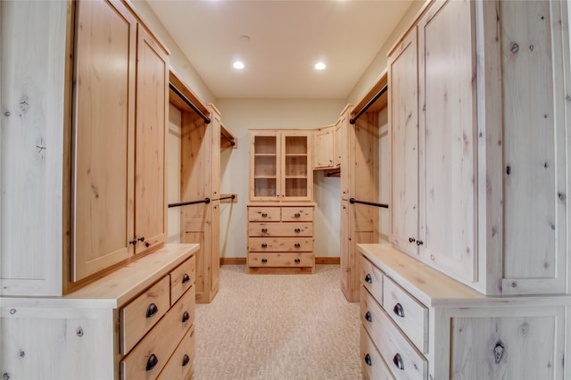 walk in closet featuring light colored carpet